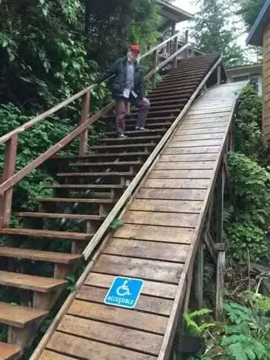 A ramp for people in a wheelchair that is very steep so that it's likely impossible to use it